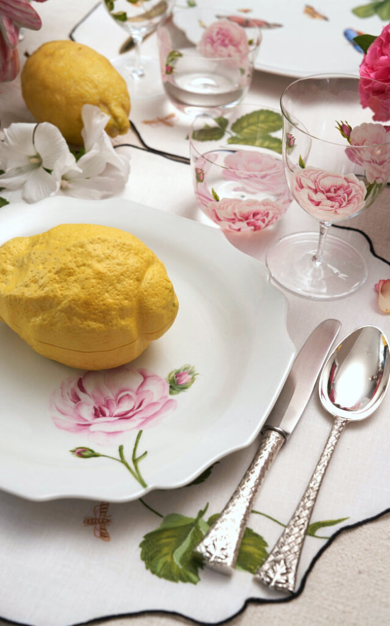 Table dressée de la collection Giambattista Valli : porcelaine à décor de roses, citrons et verres peints à la fleur