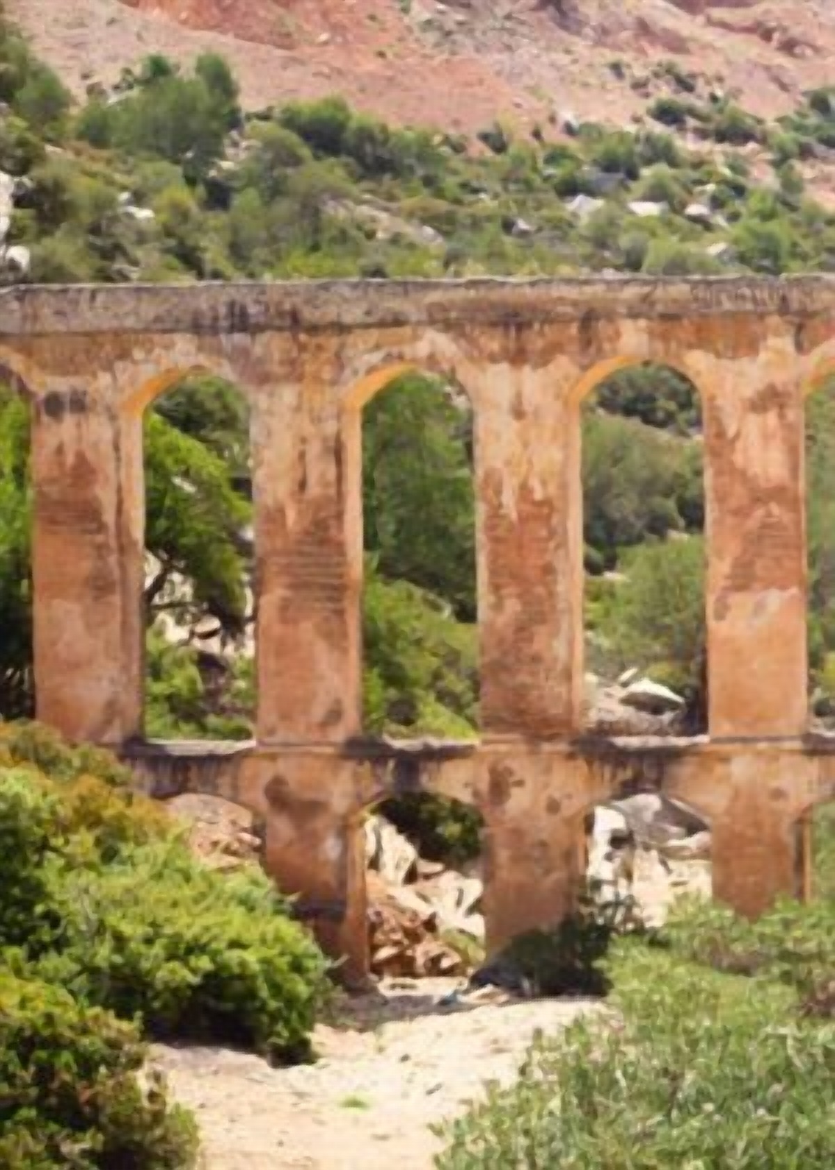 Ancien aqueduc à arches de pierre au pied de la montagne