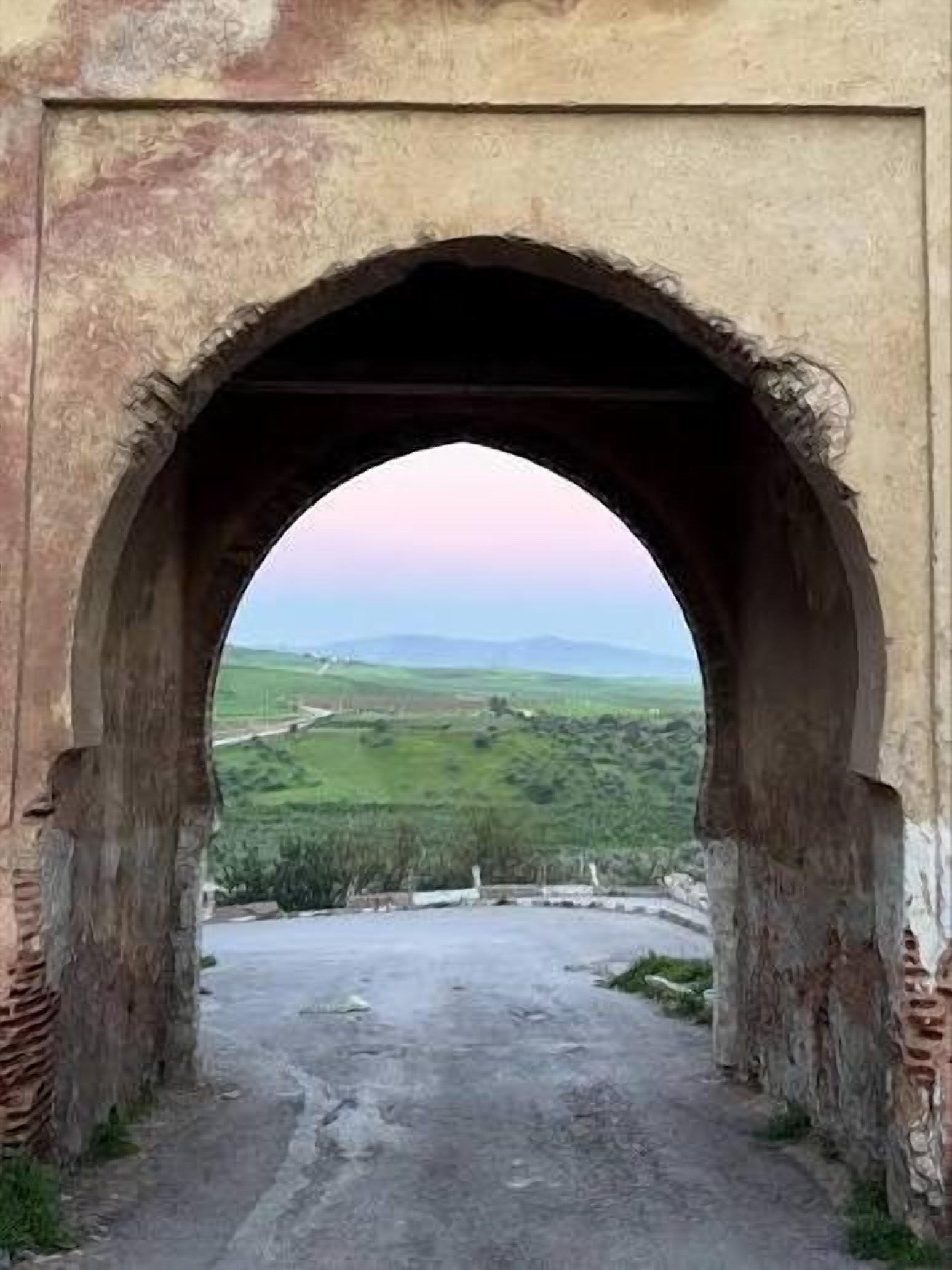 Porte marocaine en arc outrepassé ouvrant sur les collines du Zerhoun
